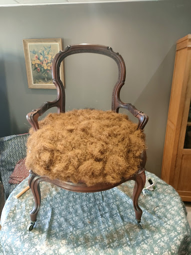 Fauteuil ancien pendant sa restauration, avant pose du tissu