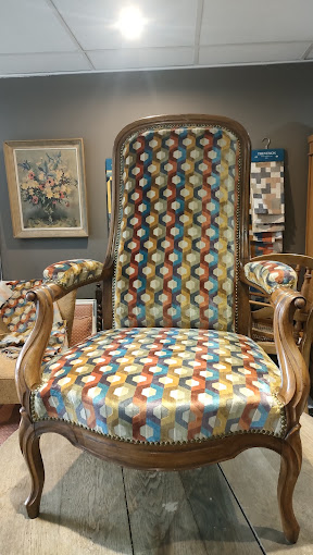 Fauteuil Voltaire ancien restauré avec un tissu géométrique multicolore